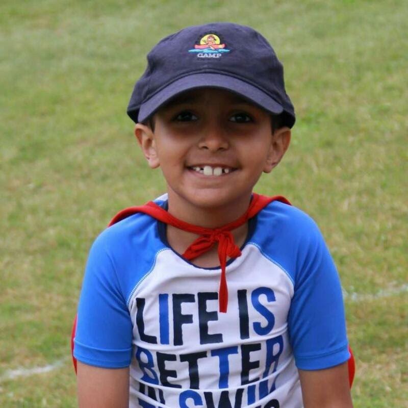 Shiven smiling in a navy cap and a red cape